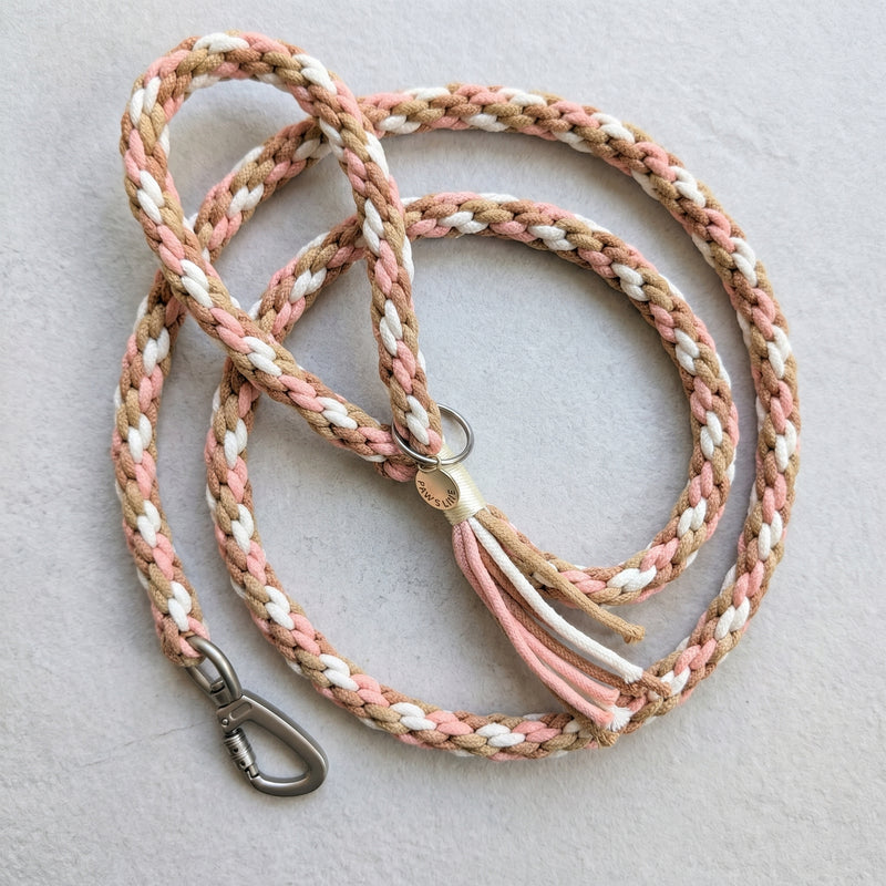 The hand-woven braided cotton rope dog leash in Desert Mirage by Paw's Line, featuring soft brown, cream, and pink strands. color:Desert Mirage