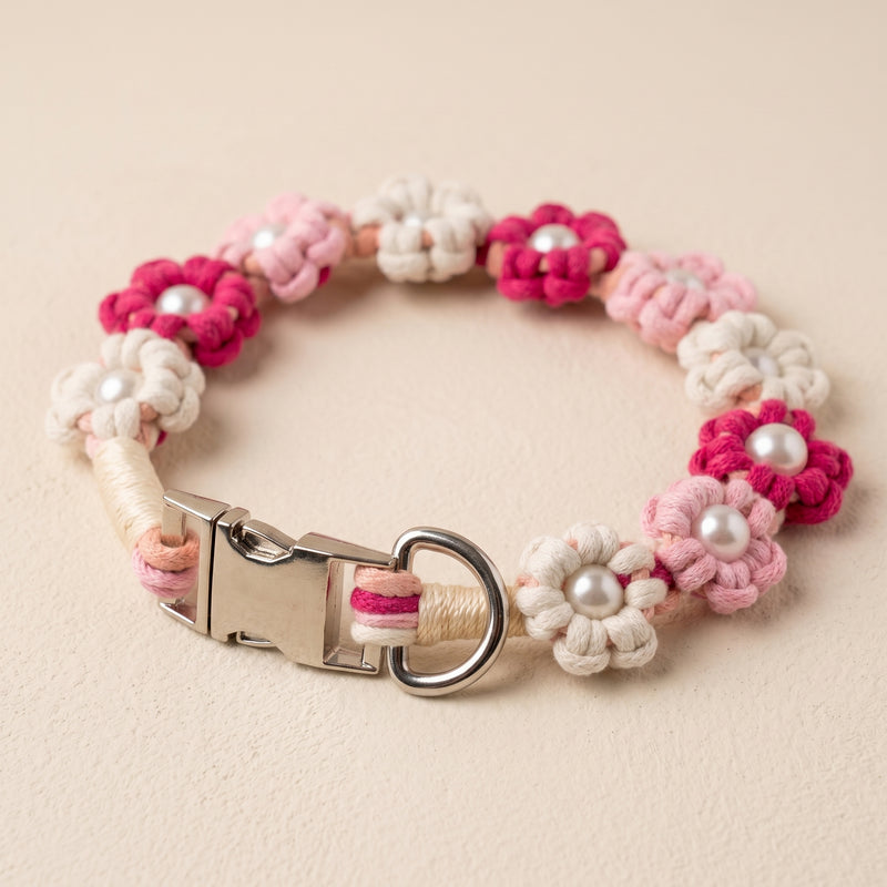 Paw's Line macrame flower dog collar. color:Flamingo Swirl. Displayed as a standalone loop on a warm cream backdrop with a metal buckle.