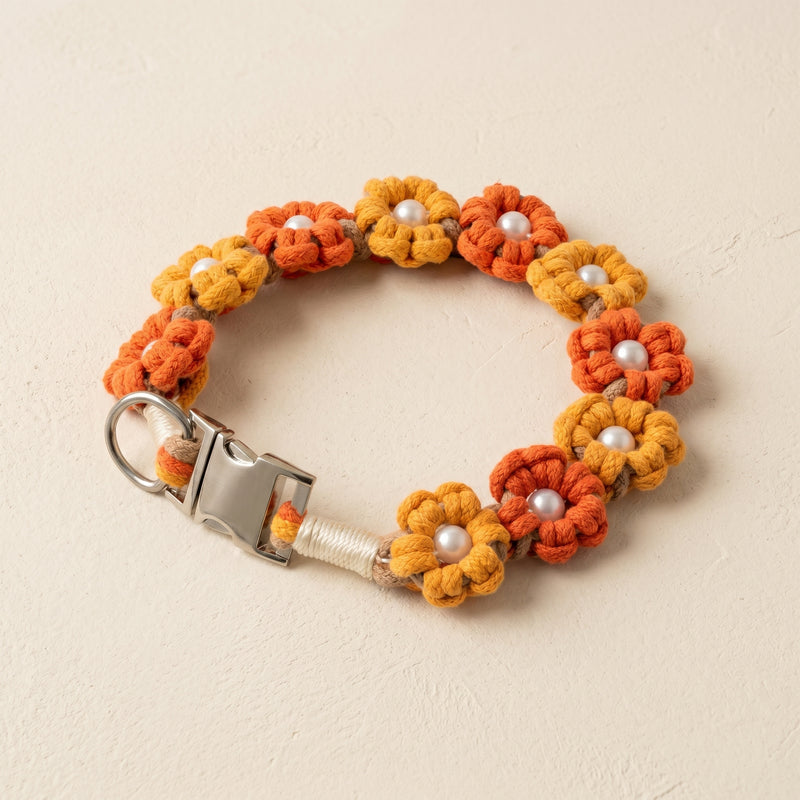 Paw's Line macrame flower dog collar. color:Summer Sun. Displayed as a standalone loop on a warm cream backdrop with a metal buckle.