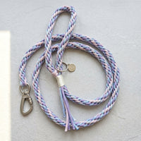The Traverse Braided Paracord Leash in Lavender Frost by Paw's Line, loosely looped on a grey textured studio surface. color:Lavendar Frost
